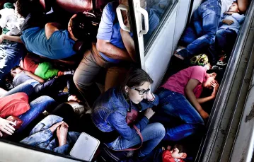Syryjscy uchodźcy w pociągu jadącym z Macedonii do Serbii, 30 sierpnia 2015 r. / Fot. Aris Messinis / AFP / EAST NEWS