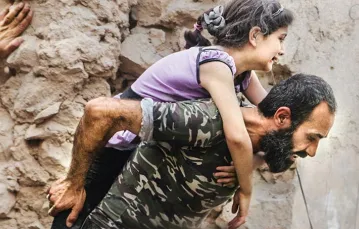 Syryjski powstaniec i dziewczynka ranna w nalocie na wschodnią, pozostającą pod kontrolą opozycji, część Aleppo. 8 lipca 2016 r.  / Fot. Abdalrhman Ismail / REUTERS / FORUM