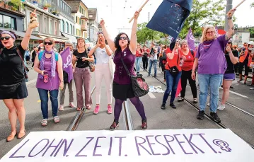 W czerwcu 2019 r. kilkaset tysięcy kobiet wzięło udział w strajku generalnym, domagając się równouprawnienia. Na zdjęciu: protestujące Szwajcarki w Zurychu; napis na transparencie głosi: „Płaca. Czas. Szacunek”. / ARND WIEGMANN / REUTERS / FORUM