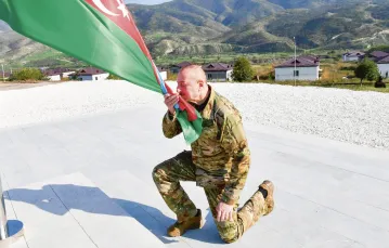 Symbol ormiańskiej klęski: prezydent Ilham Alijew wciąga na maszt flagę Azerbejdżanu w centrum Stepanakertu/Chankendi, stolicy Karabachu. 15 października 2023 r. / Abaca Press / Forum
