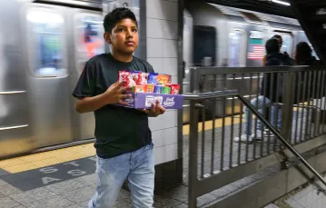 Młody chłopiec sprzedaje słodycze na stacji metra. Nowy Jork, 18 sierpnia 2023 r. / Fot. Spencer Platt / Getty Images 