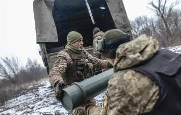 Ukraińscy żołnierze rozładowują ładunki wybuchowe na stanowisku bojowym w kierunku Bachmutu. Obwód doniecki, 22 lutego 2024 r. / Diego Herrera Carcedo / ANADOLU / AFP / EAST NEWS