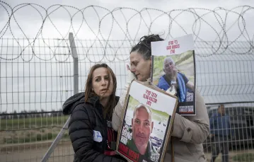 Maya Palty (po lewej) z rodziny Elada Katzira oraz Efrata Machikawa, której krewny również został uprowadzony z kibucu Nir Oz w południowym Izraelu. Granica strefy Gazy, 11 stycznia 2024 r. // Fot. Maya Alleruzzo / AP  / East News