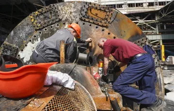 Pracownicy naprawiają elektrownię zniszczoną przez rosyjskie rakiety w pobliżu Charkowa. Ukraina, 12 kwietnia 2024 r. // Fot. Andrii Marienko / AP / East News
