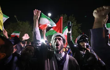 Demonstranci z irańskimi i palestyńskimi flagami w noc irańskiego ataku zebrali się pod brytyjską ambasadą w Teheranie. Teheran, 14 kwietnia 2024 r. / fot. ATTA KENARE/AFP/East News