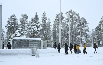 Fińska Straż Graniczna eskortuje migrantów przybywających na międzynarodowe przejście graniczne Raja-Jooseppi w Inari. Północna Finlandia, 25 listopada 2023 r. // Fot. Emmi Korhonen / East News