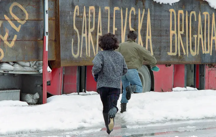 Ludzie uciekający przed snajperami do autobusu wiozącego legendarną „brygadę Sarajewa”. Bośnia, Sarajewo, 28 marca 1993 r. // Fot. Vincent Amaly / AFP / East News