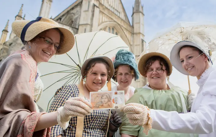 Miłośniczki Jane Austin pozują z dziesięciofuntowych banknotem przedstawiającym pisarkę, przed katedrą w Winchesterze. Anglia, 18 lipca 2017 r. // Fot. Steve Parsons / PA / Getty Images
