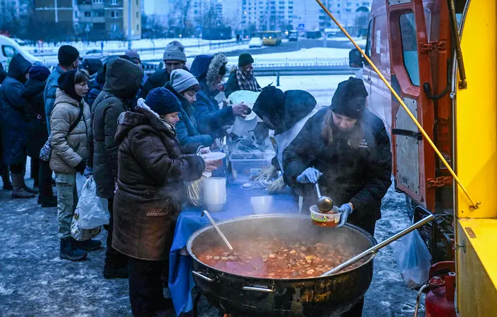 Wolontariusze organizacji charytatywnej World Central Kitchen rozdają ciepłe posiłki mieszkańcom Kijowa, 22 stycznia 2026 r. // Fot. Sergei Gapon / AFP/ East News