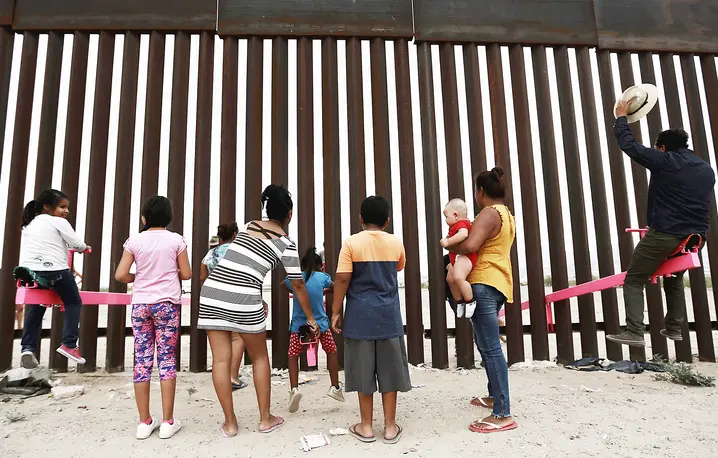 Huśtawki przerzucone przez płot na granicy między Meksykiem a USA (instalacja artystyczna). Ciudad de Juarez, lipiec 2019 r. // Fot. Christian Chavez / AP / East News