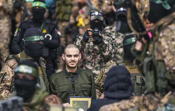 Omer Wenkert w otoczeniu bojowników z Hamasu podczas wymiany izrealeskich zakładników w obozie dla uchodźców Nuseirat w Deir al-Balah w Strefie Gazy, 22 lutego 2025 r. // Fot. Abdel Kareem Hana / AP / East News