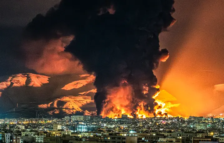 Toksyczne chmury nad stolicą Iranu w trakcie nalotu na rafinerię, położoną w północno-zachodniej części Teheranu. 7 marca 2026 r. // Fot. Sasan / Middle East Images / AFP / East News