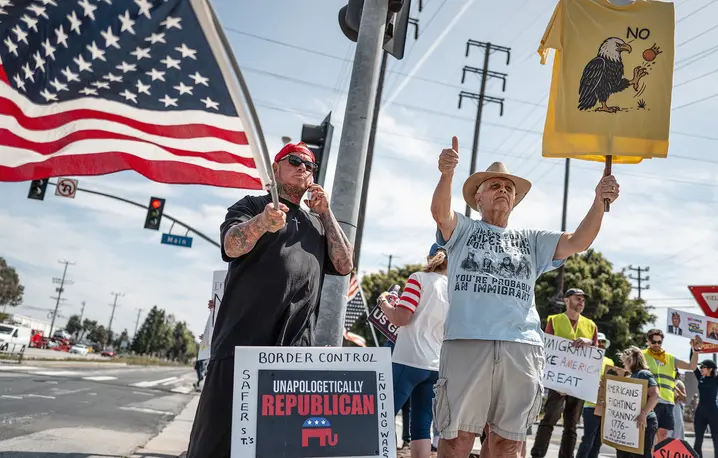 Do starcia nie doszło: samotny zwolennik Trumpa (z lewej) i krytycy prezydenta podczas protestu w 15-tysięcznym mieście El Segundo w Kalifornii. W sobotę 28 marca w całych Stanach około osiem milionów Amerykanów protestowało przeciw Trumpowi pod hasłem „No Kings”. // Fot. Jay L Clendenin / Getty Images
