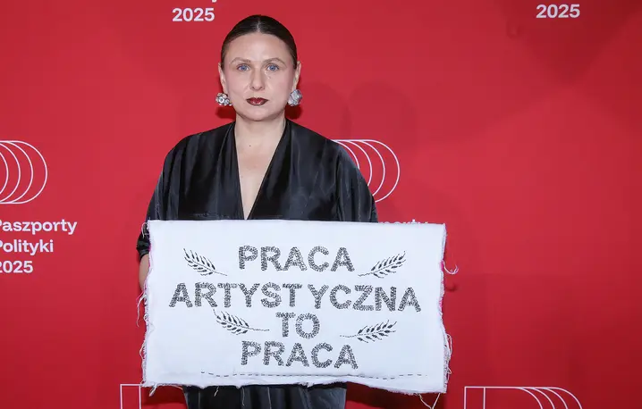 Monika Drożyńska z haftem „Praca artystyczna to praca", symbolizującym debatę o wynagrodzeniach dla artystów. Gala Paszportów Polityki 2025., 10 stycznia 2026 r. // Fot. Rafał Guz / PAP