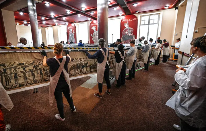 Pracownicy i wolontariusze przygotowują się do zapakowania Tkaniny z Bayeux do kontenerów, w których zostanie przewieziona do Muzeum Brytyjskiego w Londynie. Bayeux, 18 września 2025 roku. // Fot. Lou Benoist / Pool / AFP / East News 