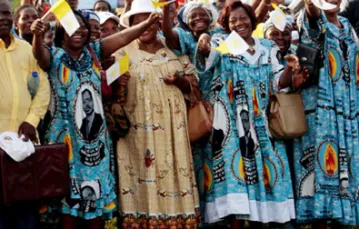 Mieszkańcy Jaunde (Kamerun) w czasie przejazdu papamobile. W tle na billboardzie, obok Papieża - prezydent Kamerunu. 18 marca 2009 r. /fot. KNA-Bild / 