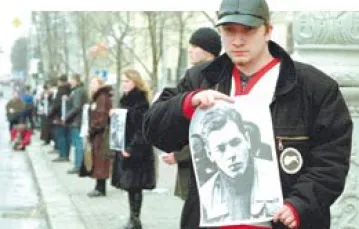 Mińsk: demonstranci trzymają zdjęcia osób "zaginionych". / 
