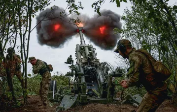 Na linii frontu w obwodzie charkowskim.  Żołnierze ukraińscy wystrzeliwują pocisk z amerykańskiej haubicy M777. Ukraina, 21 lipca 2022 r.   / GLEB GARANICH / REUTERS / FORUM
