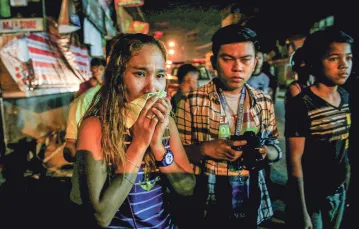 Mieszkańcy Quezon niedaleko Manili obserwują, jak policja zabezpiecza ciało podejrzanego  o handel narkotykami, którego zastrzelili „nieznani sprawcy”, marzec 2017 r. / ROMEO RANOCO / REUTERS / FORUM