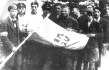 Żołnierze międzynarodowego plutonu AK z flagą Słowacji / 