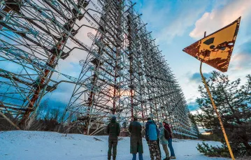 Turyści zwiedzają pozostałości po stacji radarowej „Duga” w Czarnobylu. Zwana „Okiem Moskwy”, podczas zimnej wojny stacja ta należała do sowieckiego systemu wczesnego ostrzegania. Styczeń 2020 r. / FOT. SERGEY DOLZHENKO / EPA / PAP / 
