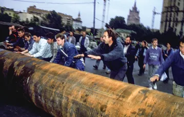 Demonstranci przetaczają pod rosyjski Biały Dom metalową rurę, aby zbudować barykadę i stawić opór puczystom. Moskwa, 20 sierpnia 1991 r. / ALAIN NOGUES / SYGMA / GETTY IMAGES