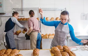 Wolontariusze pomagają przy pieczeniu i pakowaniu chleba w piekarni „Dobry chleb od dobrych ludzi”, Kijów, 25 marca 2022 r. / ANASTASIA VLASOVA / GETTY IMAGES