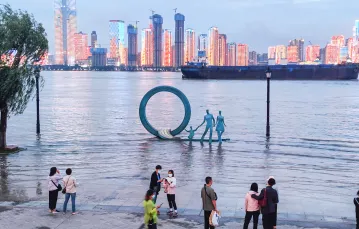 Mieszkańcy Wuhan nad rzeką Jangcy, która po obfitych opadach zalała bulwary i park. Chiny, 26 maja 2021 r. / FOT. CHINA DAILY / REUTERS / FORUM / 