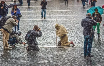 Pielgrzym klęczy podczas burzy na placu św. Piotra. Marzec 2013 r. / PIOTR TUMIDAJSKI / FORUM