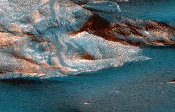 Zwietrzały piasek kryjący warstwy skał osadowych w marsjańskim kanionie Ganges Chasma. / NASA / JPL-CALTECH / UNIVERSITY OF ARIZONA