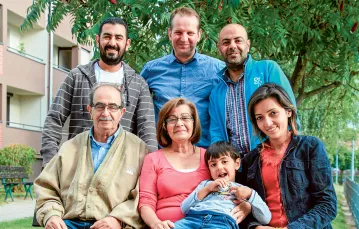 Rodzina uchodźców z Syrii z panem Tomaszem Wilgoszem (w niebieskiej koszuli). Oława, wrzesień 2015 r. / MIECZYSŁAW MICHALAK / AGENCJA GAZETA