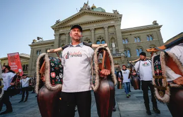 Protesty przeciw restrykcjom wspierają „wolnościowi trychlerzy”: grupa odwołująca się do ludowych tradycji i szwajcarskich mitów założycielskich, której symbolem jest krowi dzwon. Na zdjęciu: trychlerzy przed parlamentem w Bernie, 23 października 2021 r. / FABRICE COFFRINI / AFP