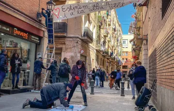 Rafael, architekt i działacz społeczny, przygotowuje transparent w trakcie sąsiedzkiego protestu na ulicy Om w dzielnicy Raval. Barcelona, 21 marca 2021 r. / PAULINA MAŚLONA