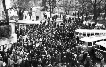 Dziedziniec Uniwersytetu Warszawskiego, od bramy. Już są autobusy z tzw. aktywem, który zaczyna od rozmówz wiecującymi. Pod Auditorium Maximum (po lewej w głębi) stoi czarna wołga, takimi jeździł wyższy „aktyw”. Koło południa, piątek 8 marca 1968 r. / fot / 