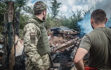 Ukraińscy żołnierze przed chwilą przeżyli ostrzał ich schronu, w tle jego resztki. Październik 2021 r. / monika andruszewska