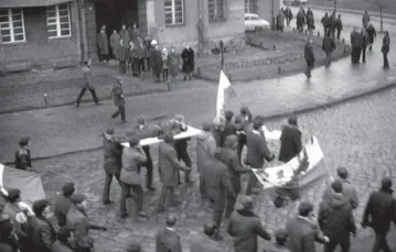 Gdynia, grudzień 1970 r.: demonstranci niosą na drzwiach zwłoki 18-letniego Zbigniewa Godlewskiego. Scena ta została uwieczniona w „Balladzie o Janku Wiśniewskim”. / fot. IPN / 