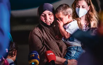 Amina, obywatelka Ukrainy, miała szczęście: ona i siedmioro jej dzieci zostało ewakuowanych z obozu jenieckiego w Syrii. Na zdjęciu opuszczają specjalny samolot, który przetransportował ich z Iraku. Lotnisko w Kijowie, 16 czerwca 2021 r. / ALINA SMUTKO