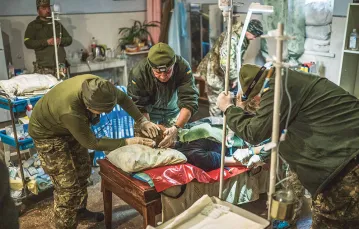 Lekarze opatrują rannego żołnierza. Szpital polowy w obwodzie chersońskim, listopad 2022 r. / PAWEŁ PIENIĄŻEK