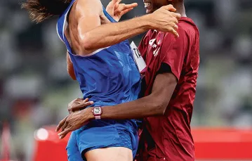 Gianmarco Tamberi i Mutaz Essa Barshim cieszą się ze wspólnego zdobycia złotego medalu w skoku wzwyż na Igrzyskach ­Olimpijskich  w Tokio 2020. Japonia, Stadion Olimpijski,  1 sierpnia 2021 r. / DAVID RAMOS / GETTY IMAGES