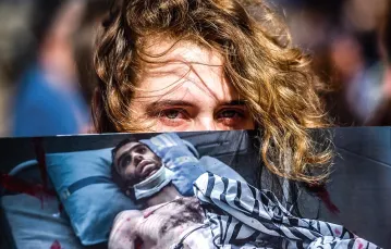 Uczestniczka protestów trzyma zdjęcie mężczyzny, który został ranny w czasie demonstracji w Mińsku 15 sierpnia 2020 r. / SERGEI GAPON / AFP / EAST NEWS