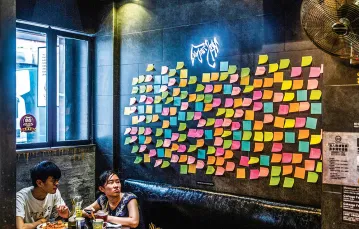 Mieszkańcy Hongkongu znajdują nowe sposoby na wyrażenie sprzeciwu: tu „ściana Lennona” w restauracji, której właściciel sympatyzuje z ruchem demokratycznym. Zapełniają ją kolorowe karteczki bez żadnych napisów. 3 lipca 2020 r. / ISAAC LAWRENCE / AFP / EAST NEWS
