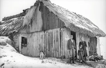 Rodzina chłopska z jednej z ponad 630 wsi, które zostały zniszczone podczas walk na przyczółkach nadwiślańskich. Zdjęcie wykonał wojskowy fotograf w roku 1949 (w opisie nie podano nazwy wioski), gdy zbudowano już przynajmniej prowizoryczne schronienia. / NARODOWE ARCHIWUM CYFROWE