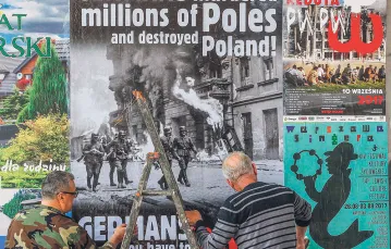 Plakat wzywający do podjęcia kwestii reparacji wojennych, Warszawa, 24 sierpnia 2017 r. / CZAREK SOKOŁOWSKI / AP / EAST NEWS