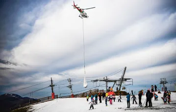 Śmigłowiec przewozi śnieg do ośrodka narciarskiego w Luchon-Superbagnères, Pireneje Francuskie, 15 lutego 2020 r. / ANNE-CHRISTINE POUJOULAT / AFP / EAST NEWS