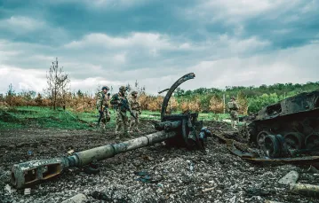 Ukraińscy żołnierze oglądają zniszczone rosyjskie działo samobieżne. Okolice Charkowa, 15 maja 2022 r. / PAWEŁ PIENIĄŻEK