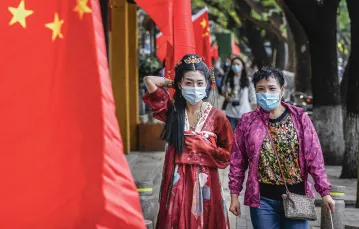 Ulice Pekinu tuż przed świętem narodowym; kobieta ubrana w tradycyjny strój hanfu. 29 września 2020 r. / KEVIN FRAYER / GETTY IMAGES