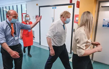 Premier Boris Johnson (w białej koszuli i maseczce) odwiedza szpital w Colchester. Dzień wcześniej jego były doradca oskarżył go o fatalne zarządzanie kryzysowe. Wschodnia Anglia, 27 maja 2021 r. / GLYN KIRK / AFP / EAST NEWS