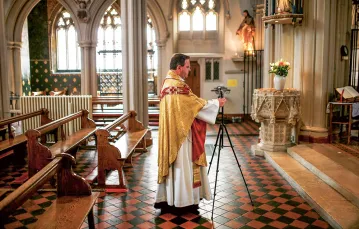 Ks. Richard Reid przygotowuje internetową transmisję mszy z kościoła Matki Bożej  w Clapham, Londyn, kwiecień 2020 r. / HENRY NICHOLLS / REUTERS / FORUM
