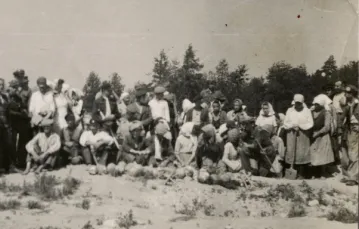 Treblinka, teren byłego obozu zagłady. Chłopi pozują dowspólnej fotografii z milicjantami, ktorzy złapali ich na rabowaniu kosztowności znalezionych przyzwłokach zabitych Żydów. U ich stóp czaszki ofiar Holokaustu. / reprodukcja zdjęcia opublikowanego w „ / 