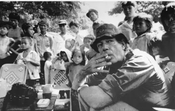 Brytyjski fotograf Tim Page wraz z kambodżańskimi dziećmi przy stoisku z kawą Chimpou. Kambodża. Zdjęcie niedatowane / / FOT. ASSOCIATED PRESS/East News